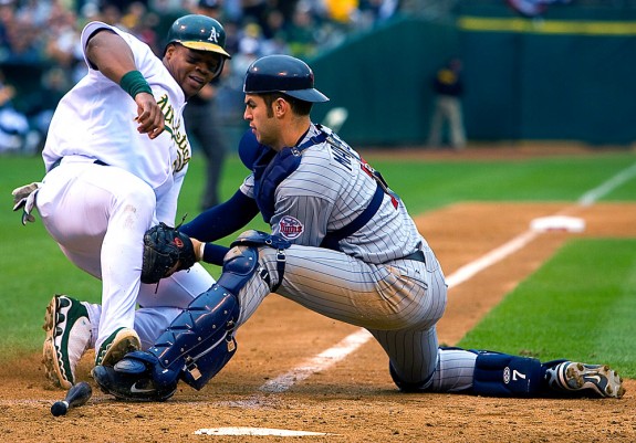 Oakland Athletics base runner Frank Thomas is tagged out at home plate by Minnesota Twins catcher Joe Mauer during Game 3 of the Amercian League Division Series at the Oakland Coliseum in Oakland, California on October 6, 2006. (Photo by Brad Mangin)