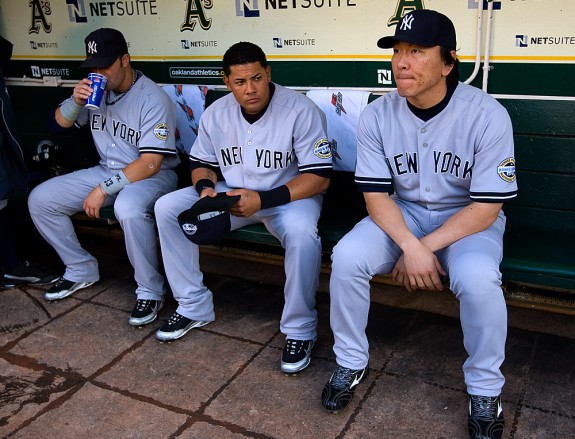 Nick Swisher #33,  Melky Cabrera #53 and Hideki Matsui #55 of the New York Yankees sit in the dugout before the game against the Oakland Athletics at the Oakland-Alameda County Coliseum on August 18, 2009 in Oakland, California. (Photo by Brad Mangin)