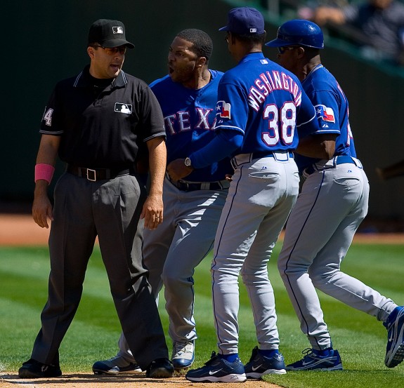 Milton Bradley of the Texas Rangers (middle) is restrained by manager Ron Washington and coach Gary Pettis from attacking first base umpire Angel Campos during the game against the Oakland Athletics at the McAfee Coliseum in Oakland, California on September 13, 2008. (Photo by Brad Mangin)